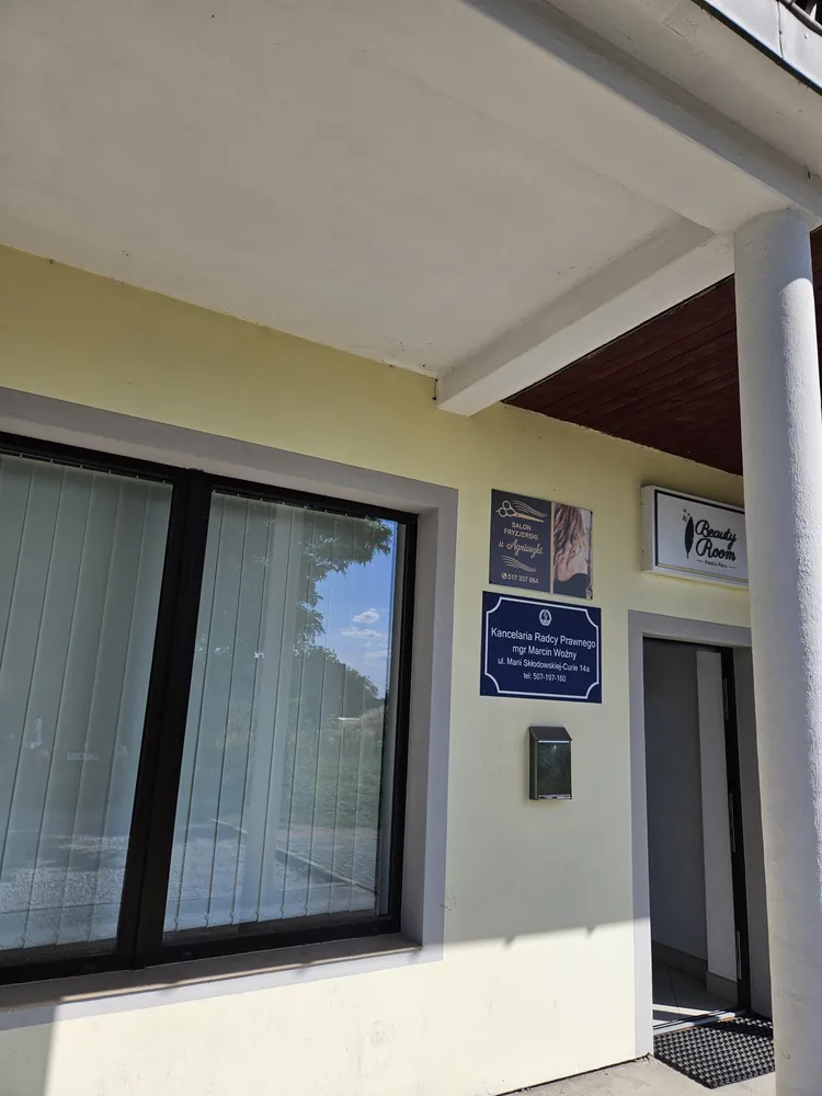 Tablica informacyjna Kancelarii Radcy Prawnego Marcin Woźny przy wejściu do budynku w Alwerni